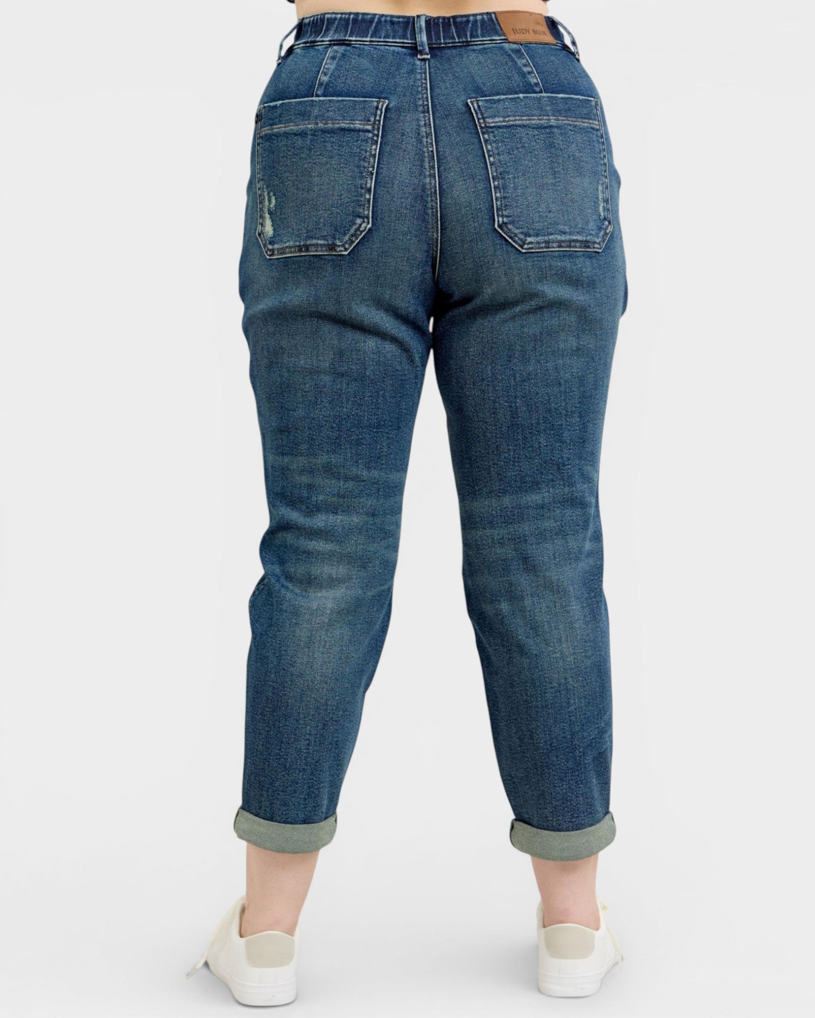 Blue jeans with rolled-up cuffs on a white background