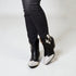 Black ankle boots with silver glittery toes worn with black pants on a white background