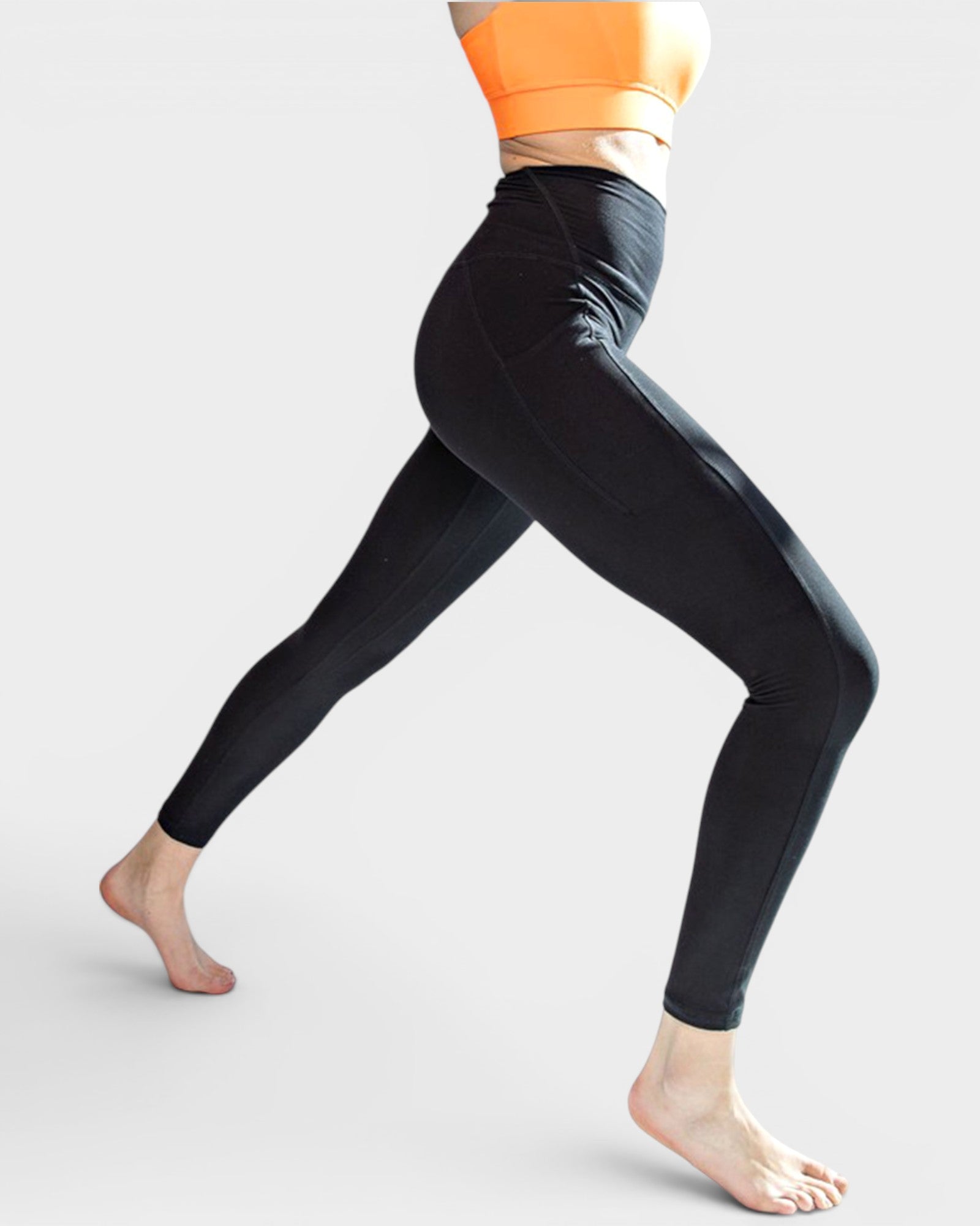 Person wearing black leggings on a light gray background
