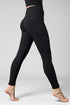 Black leggings worn by a person on a gray background