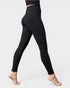 Black leggings worn by a person on a light gray background