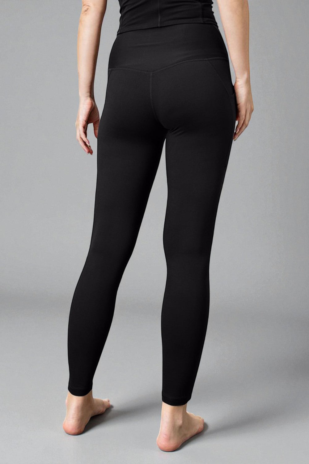 Person wearing black leggings on a gray background