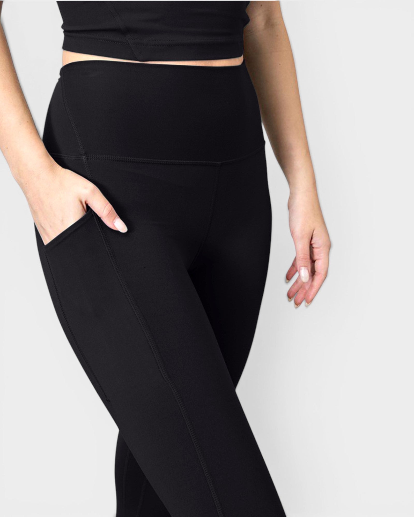 Person wearing black leggings on a plain background