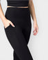 Person wearing black leggings on a plain background