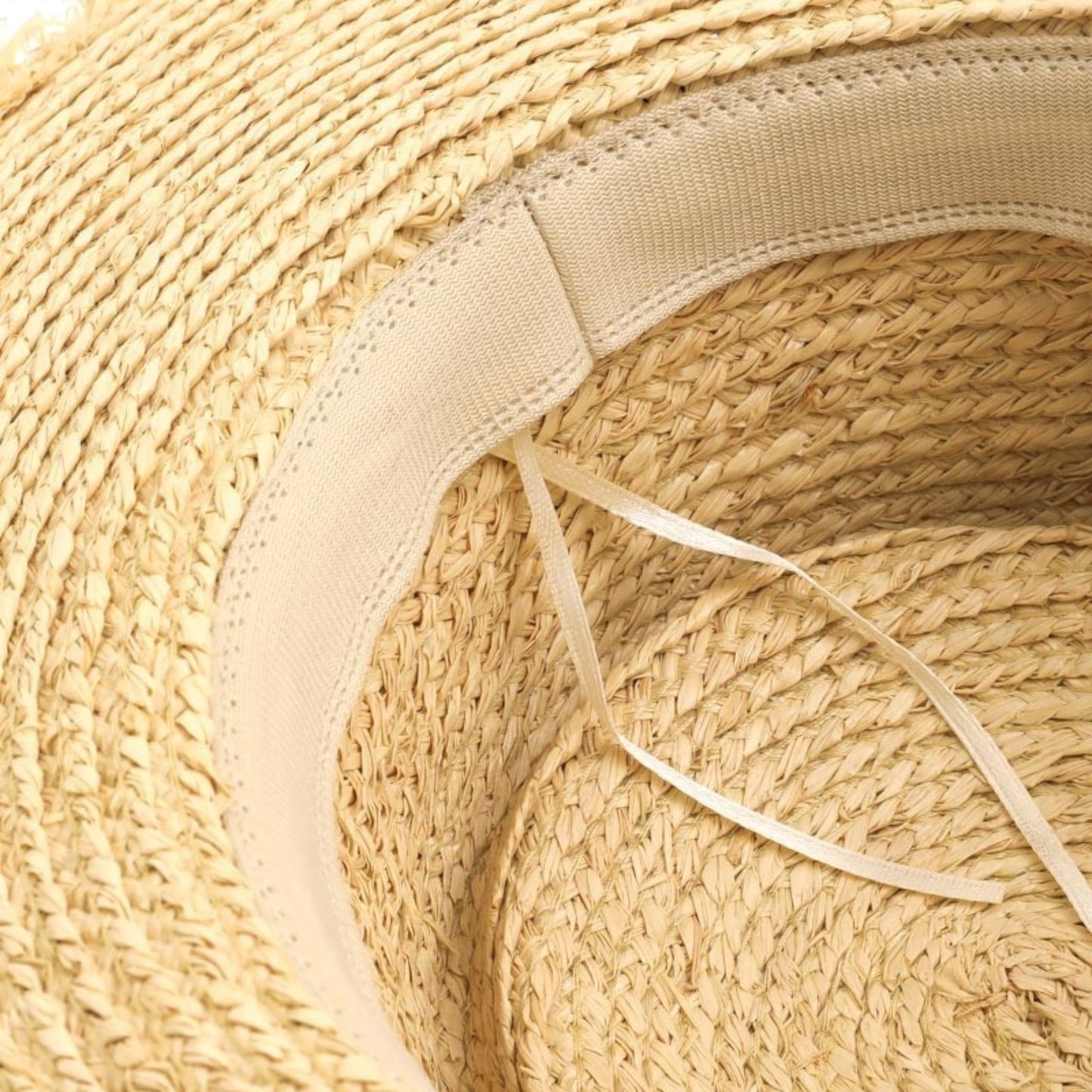 Close-up of a straw hat with a ribbon, focusing on the texture and details.