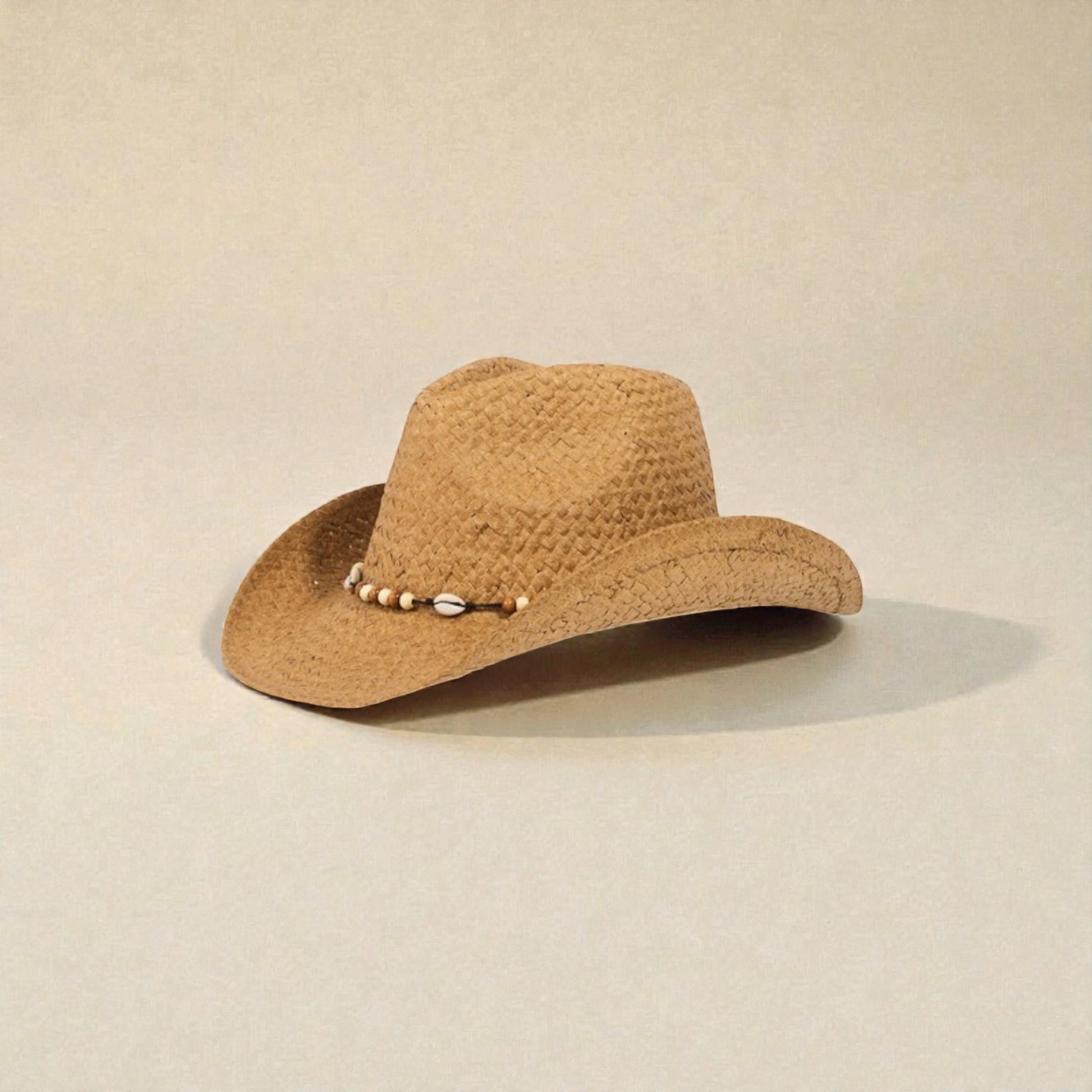 Brown straw hat with decorative elements on a beige background