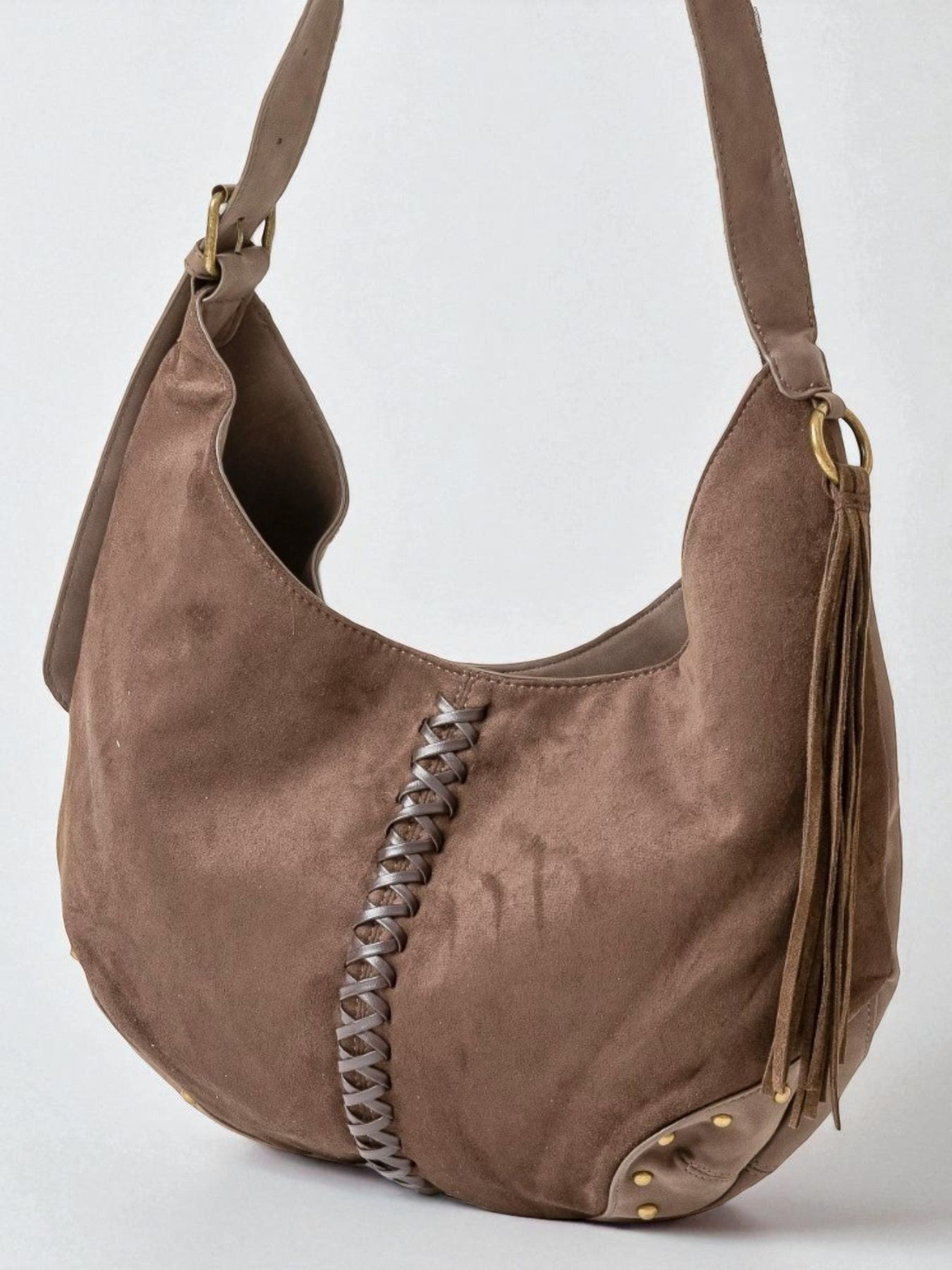 Brown suede handbag with braided detail on a white background