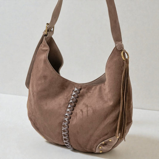 Brown suede handbag with braided detail on a white background