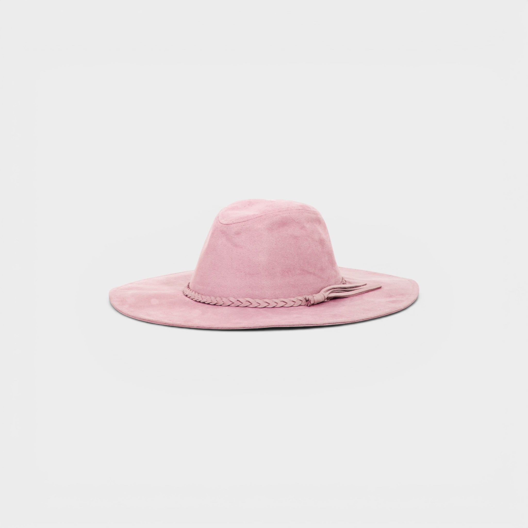 Pink suede hat with braided detail on a light gray background