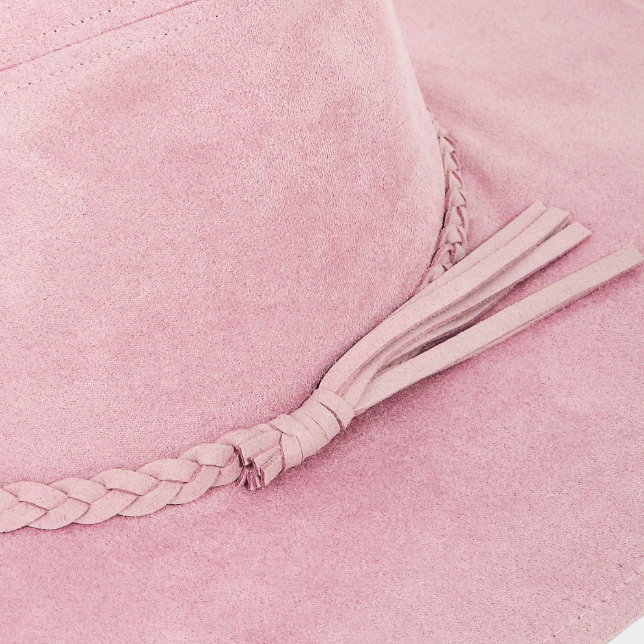 Close-up of a pink textured fabric with a braided strap and tassel.
