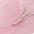 Close-up of a pink textured fabric with a braided strap and tassel.