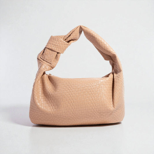 Beige handbag with textured surface on a light gray background