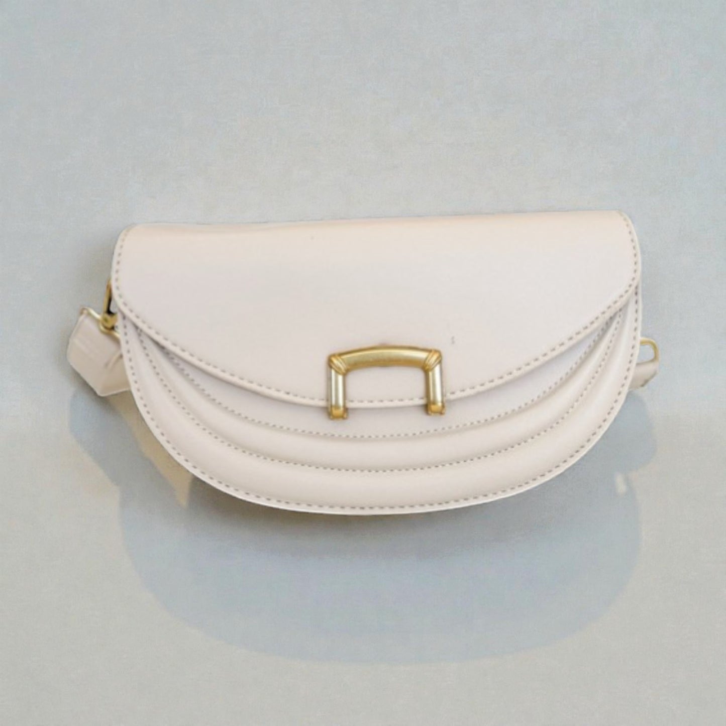 White handbag with gold accents on a light gray background