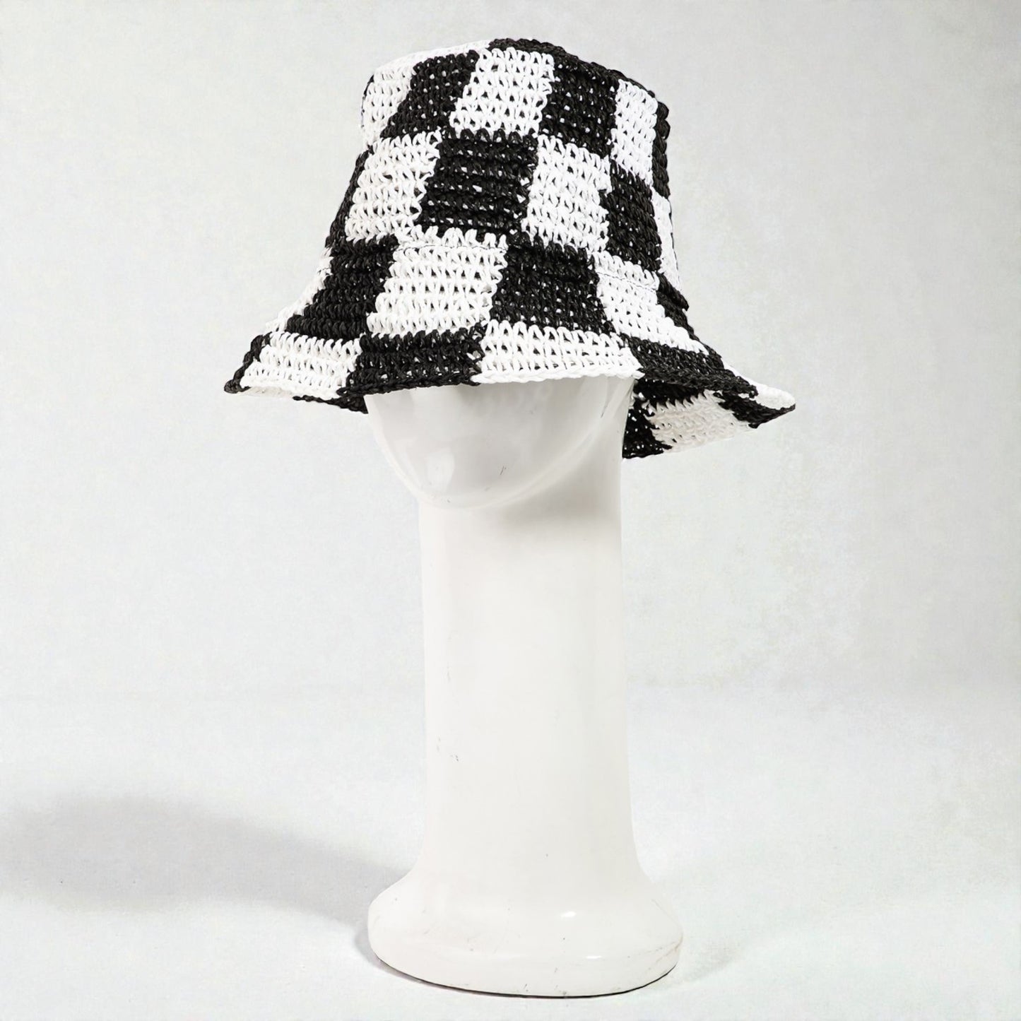 Black and white checkered bucket hat on a mannequin head against a white background