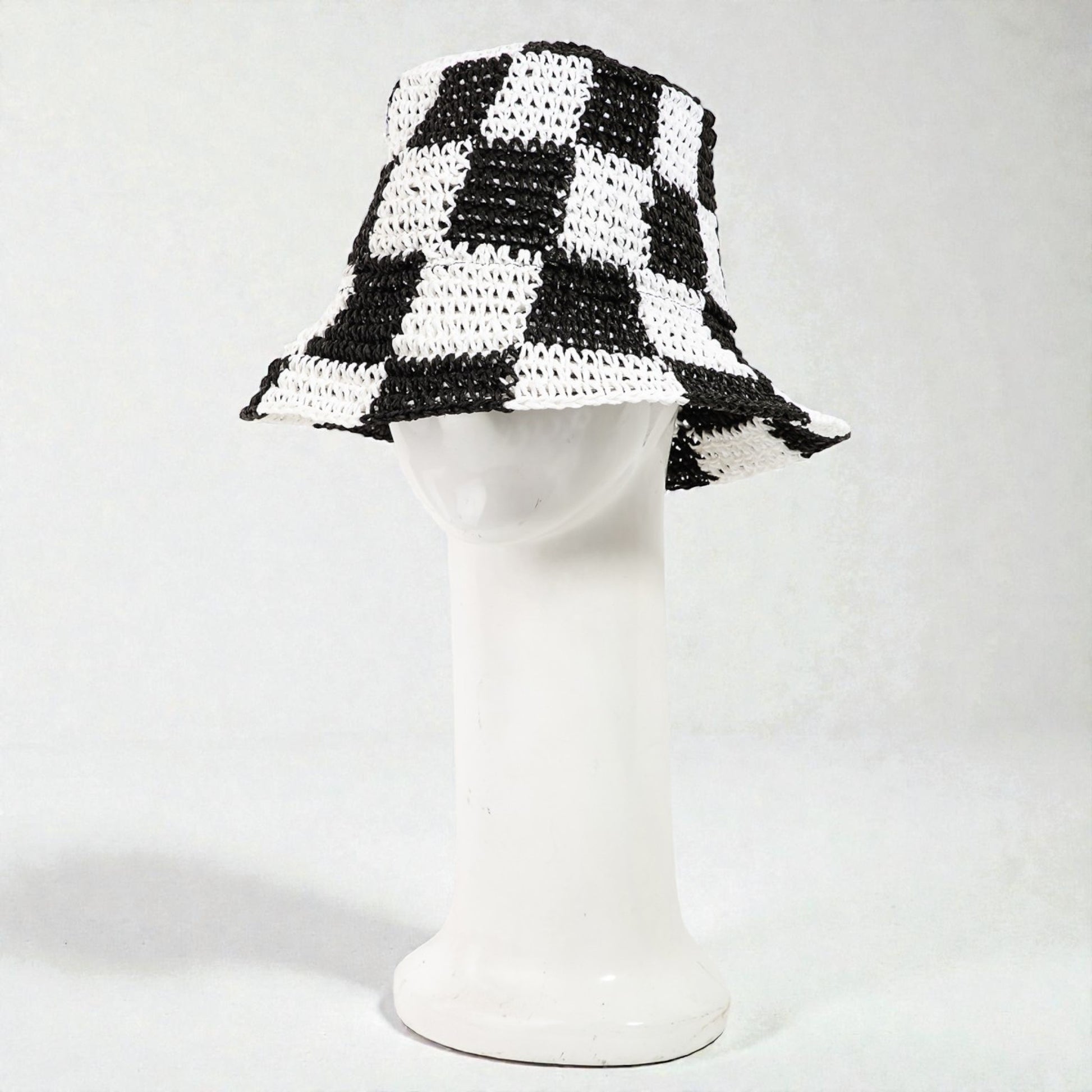 Black and white checkered bucket hat on a mannequin head against a white background