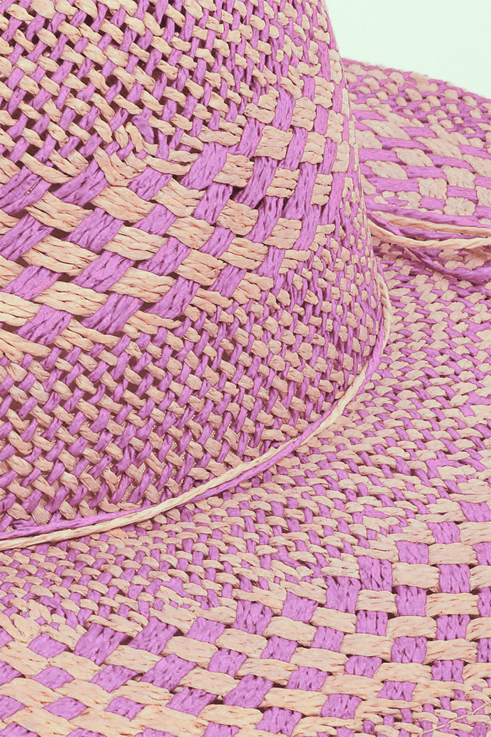 Close-up of a pink and beige woven straw hat