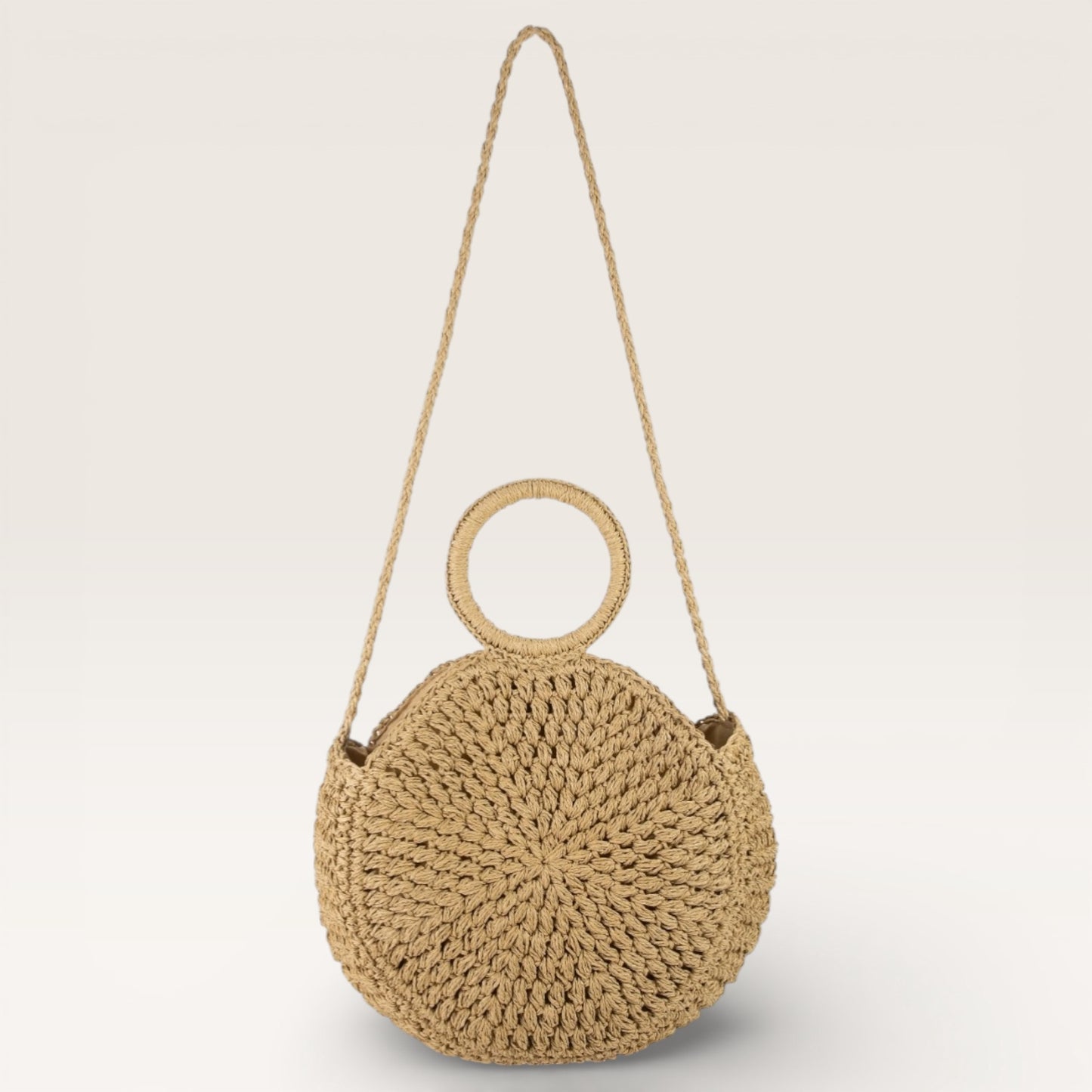 Woven handbag with circular handle on a light gray background