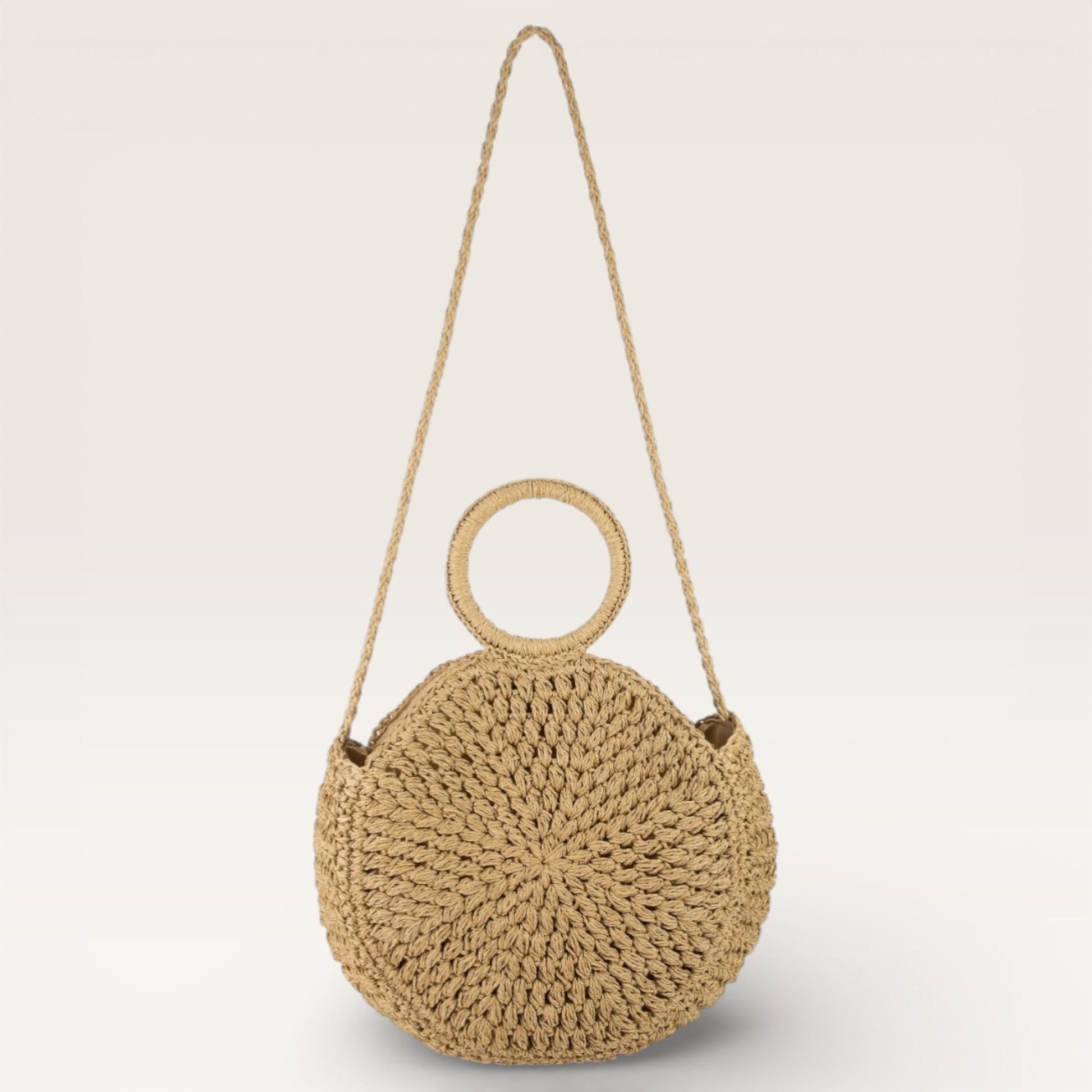 Woven handbag with circular handle on a light gray background