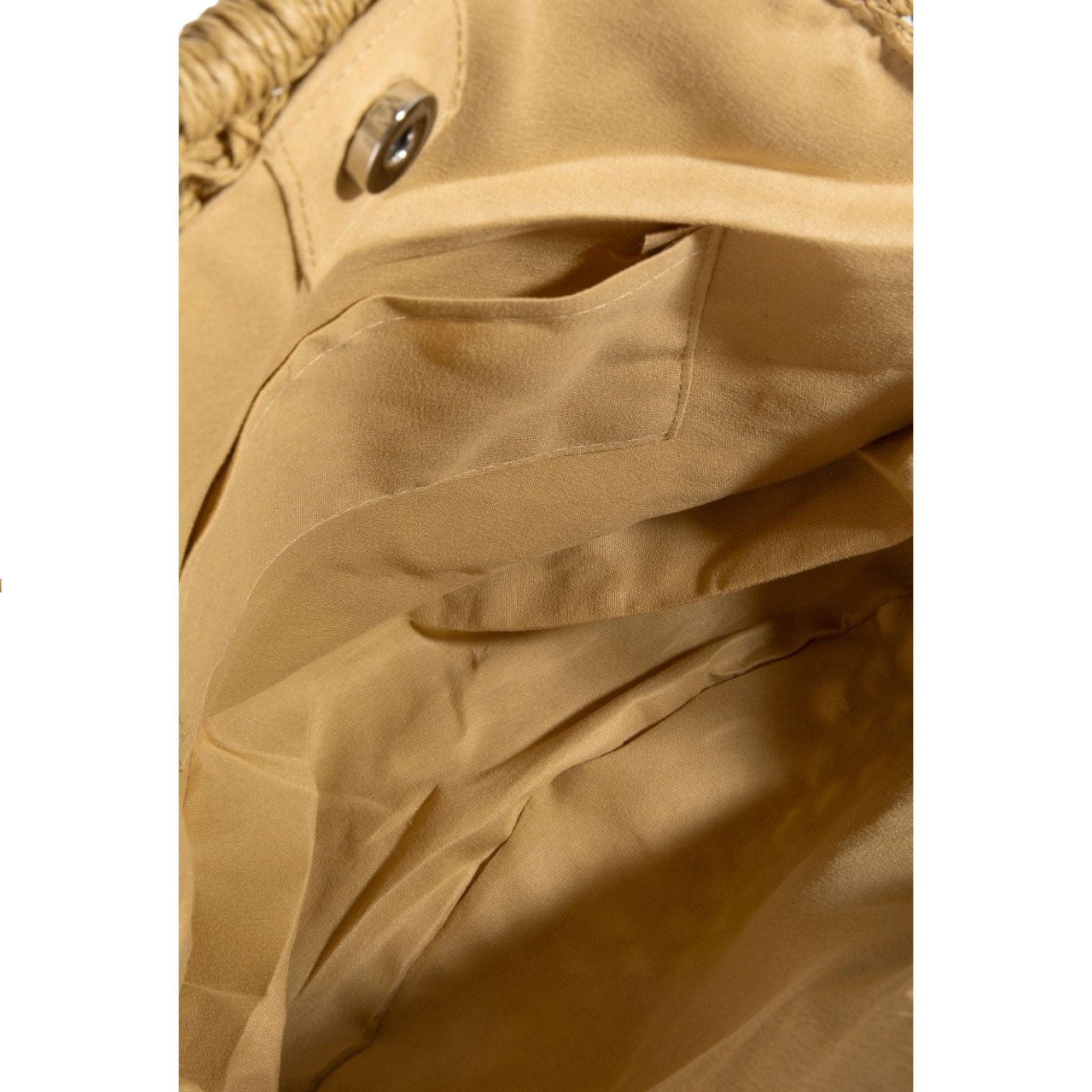 Close-up of a beige fabric texture with a button