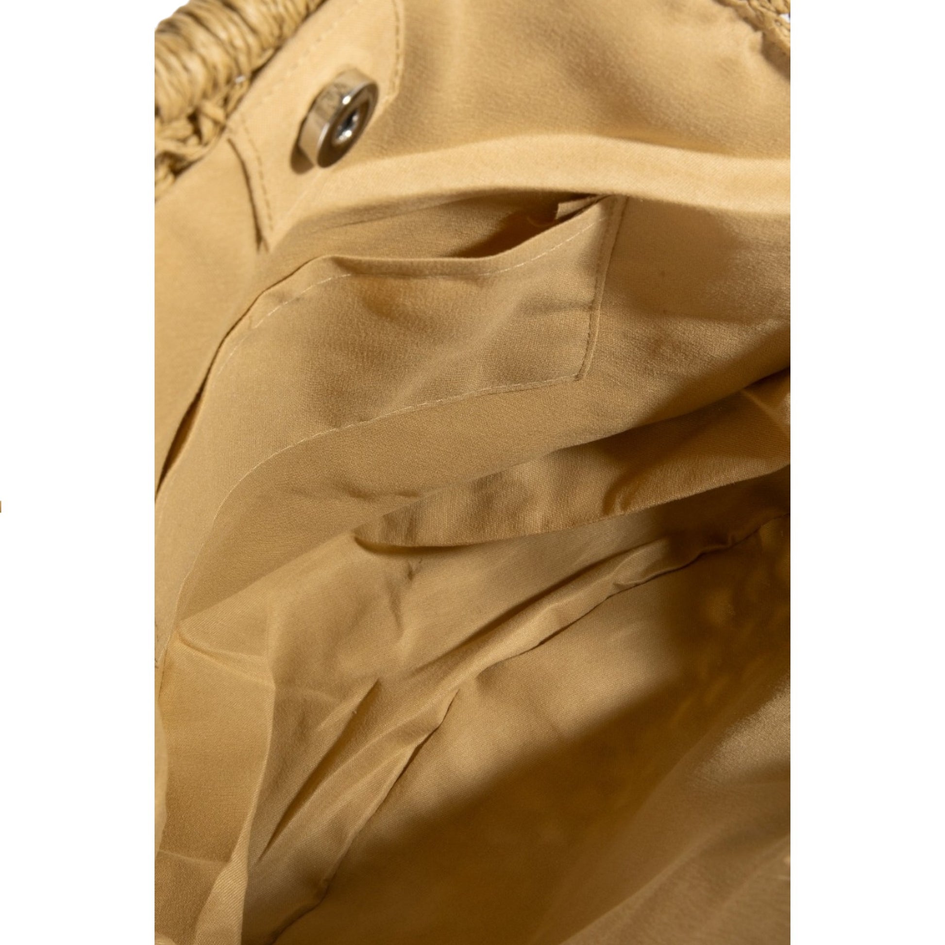 Close-up of a beige fabric texture with a button