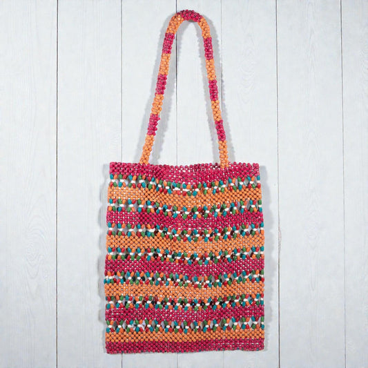 Colorful woven bag with a striped pattern on a white wooden surface