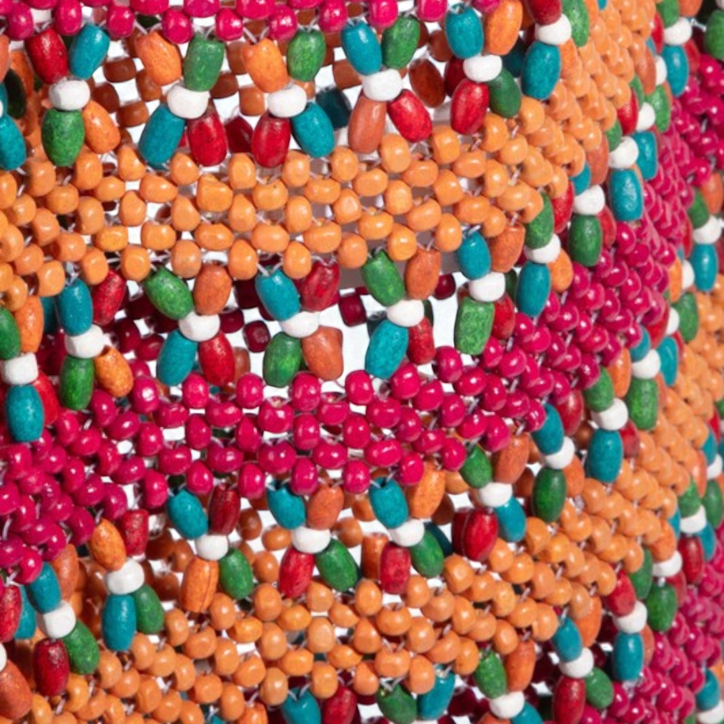 Close-up of colorful beaded pattern in red, orange, green, and white.