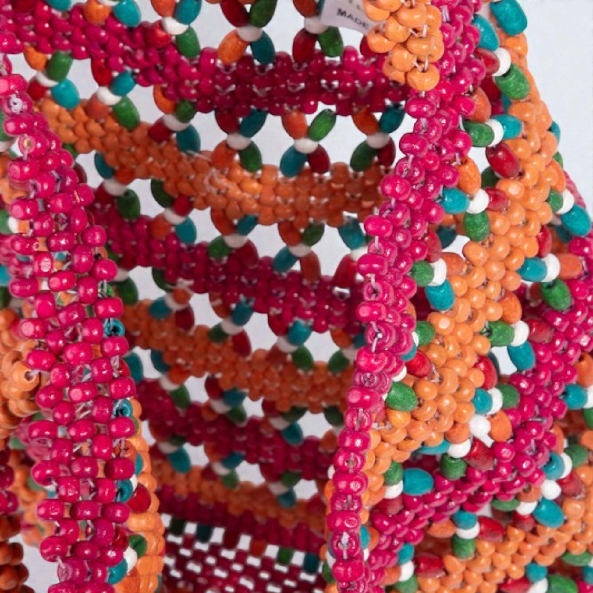 Colorful beaded necklaces stacked together on a white background