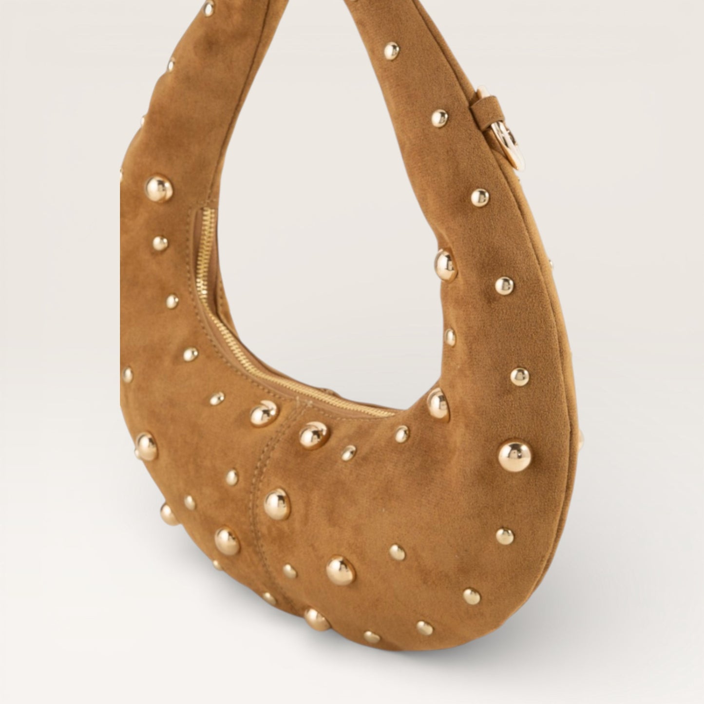 Brown suede handbag with gold studs on a light gray background