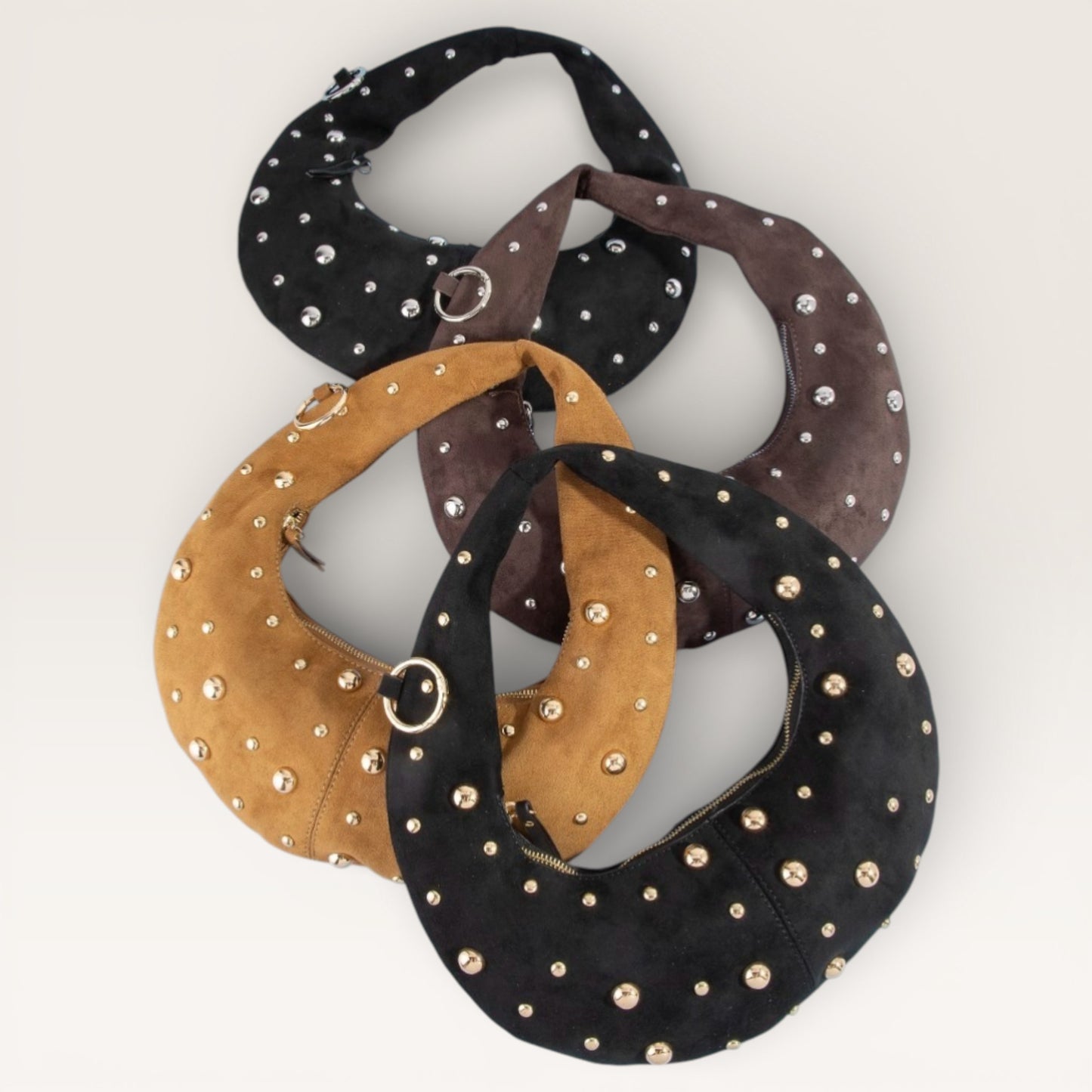 Three studded handbags in black, brown, and gold on a white background