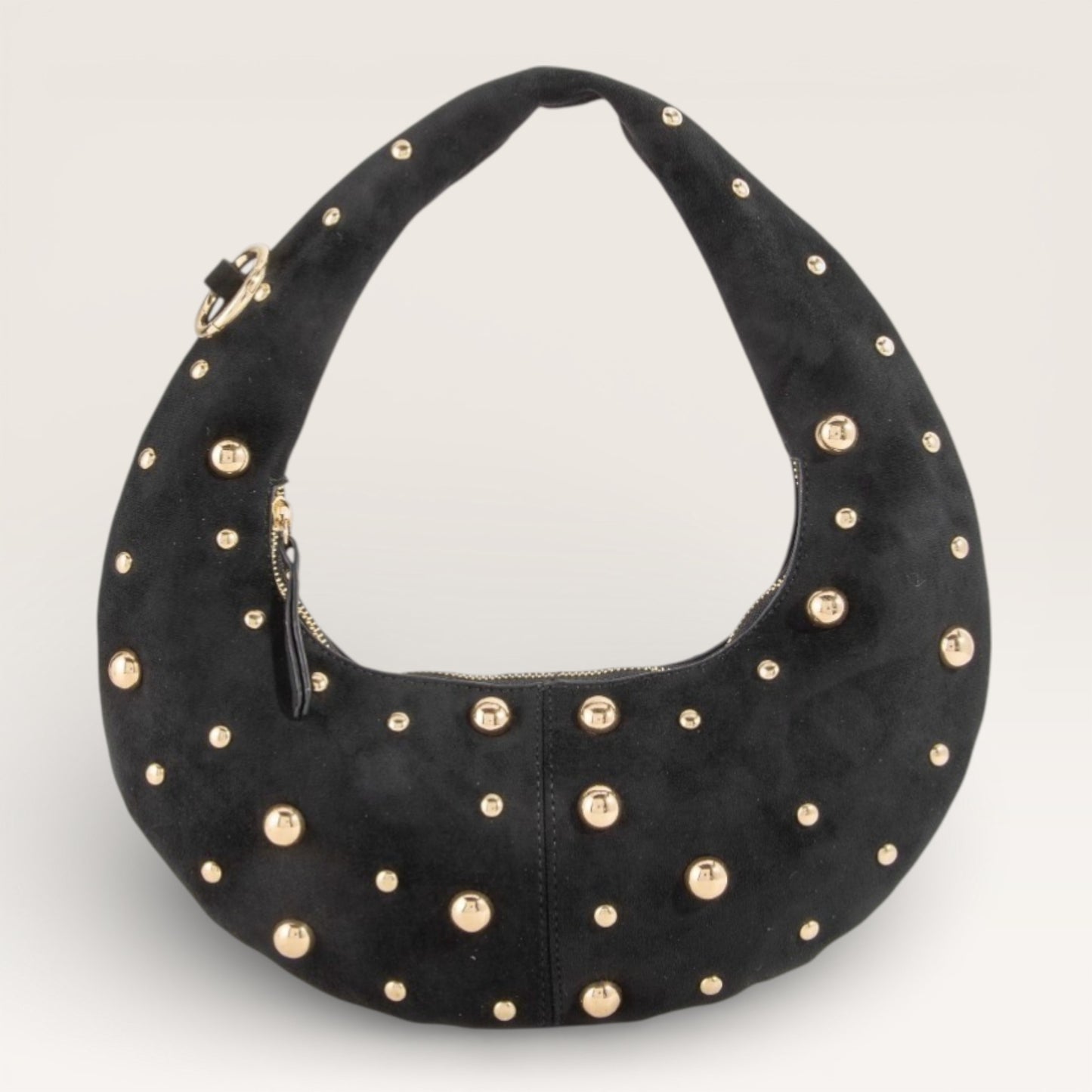Black handbag with gold studs on a light gray background