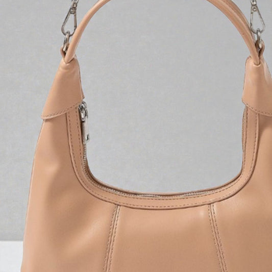 Close-up of a tan handbag with a gray background