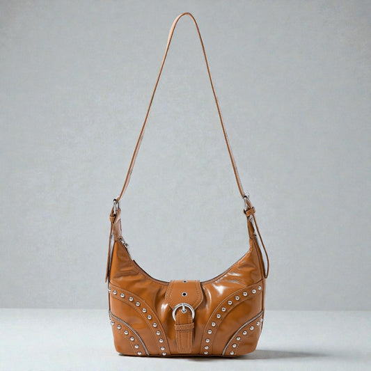Brown leather handbag with studs on a gray background