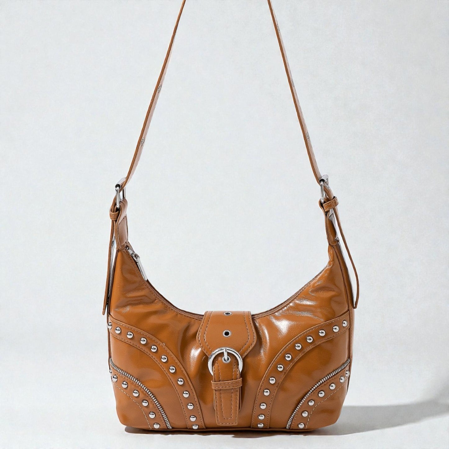 Brown leather handbag with studs on a white background