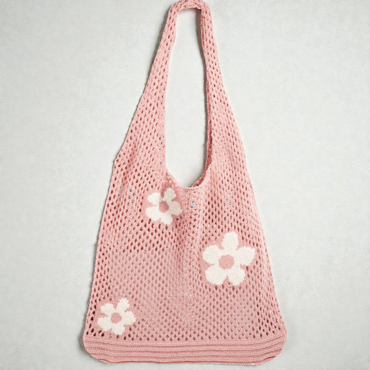 Pink crochet bag with white flowers on a light gray background