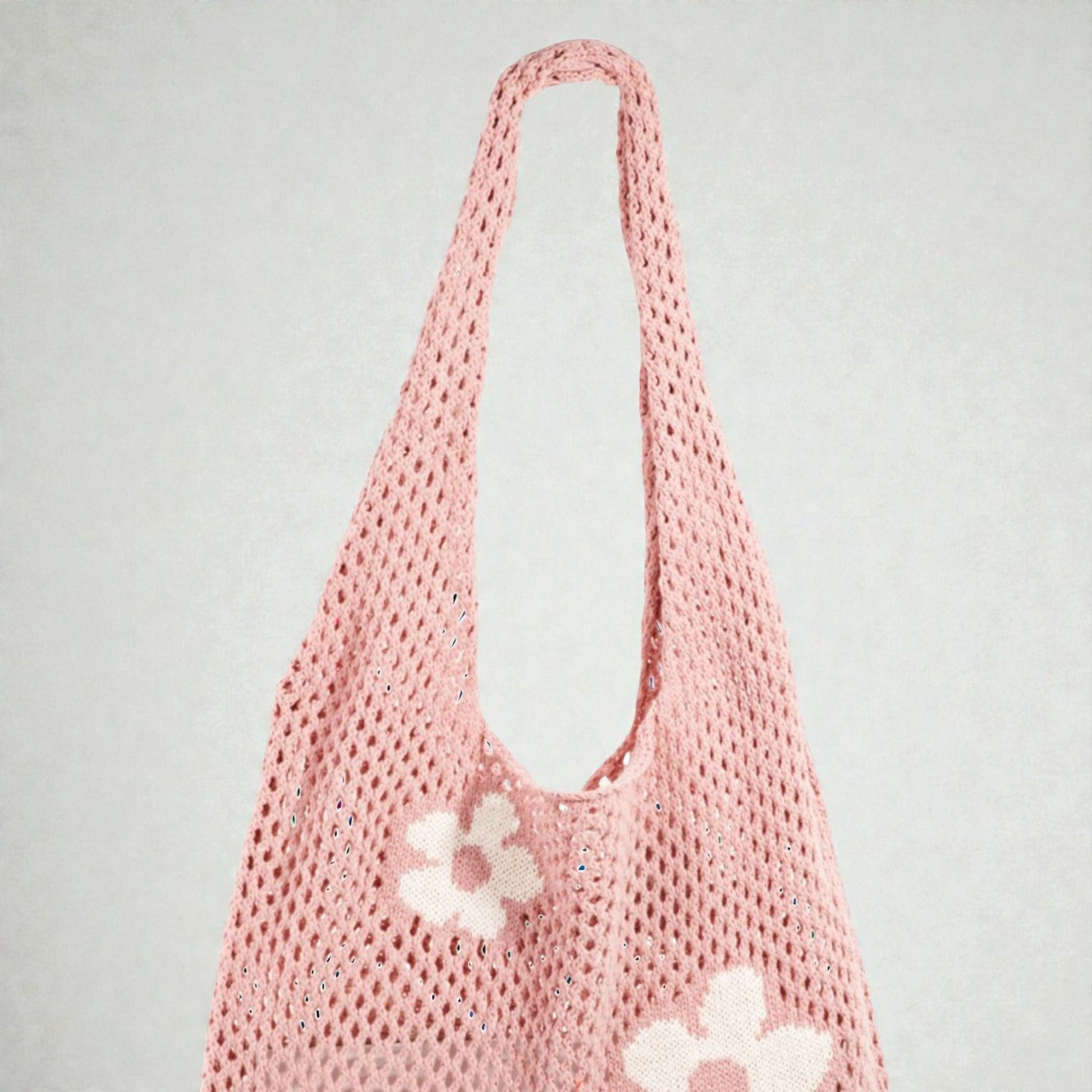 Pink mesh bag with floral details on a light gray background