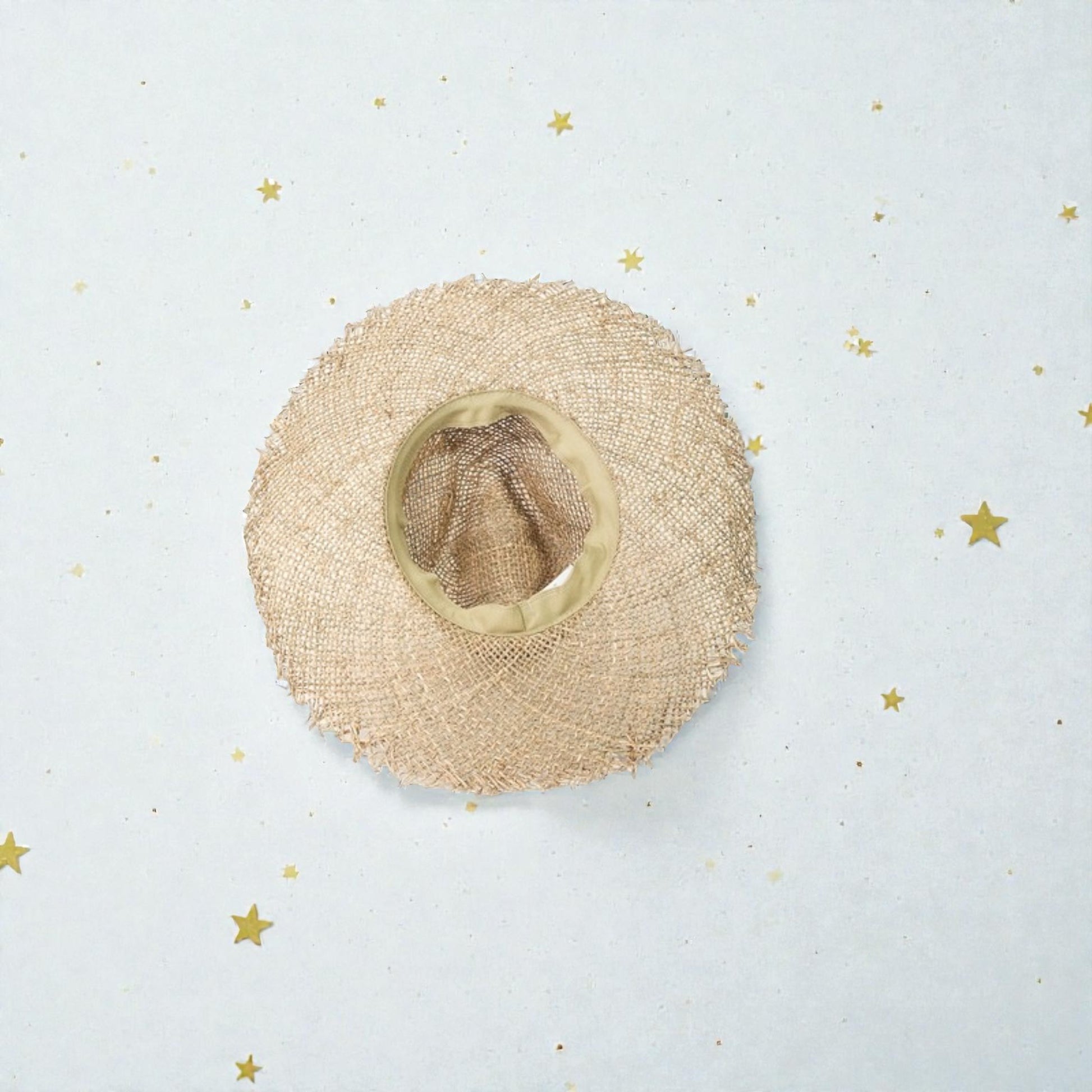 Beige straw hat on a light blue background with gold stars