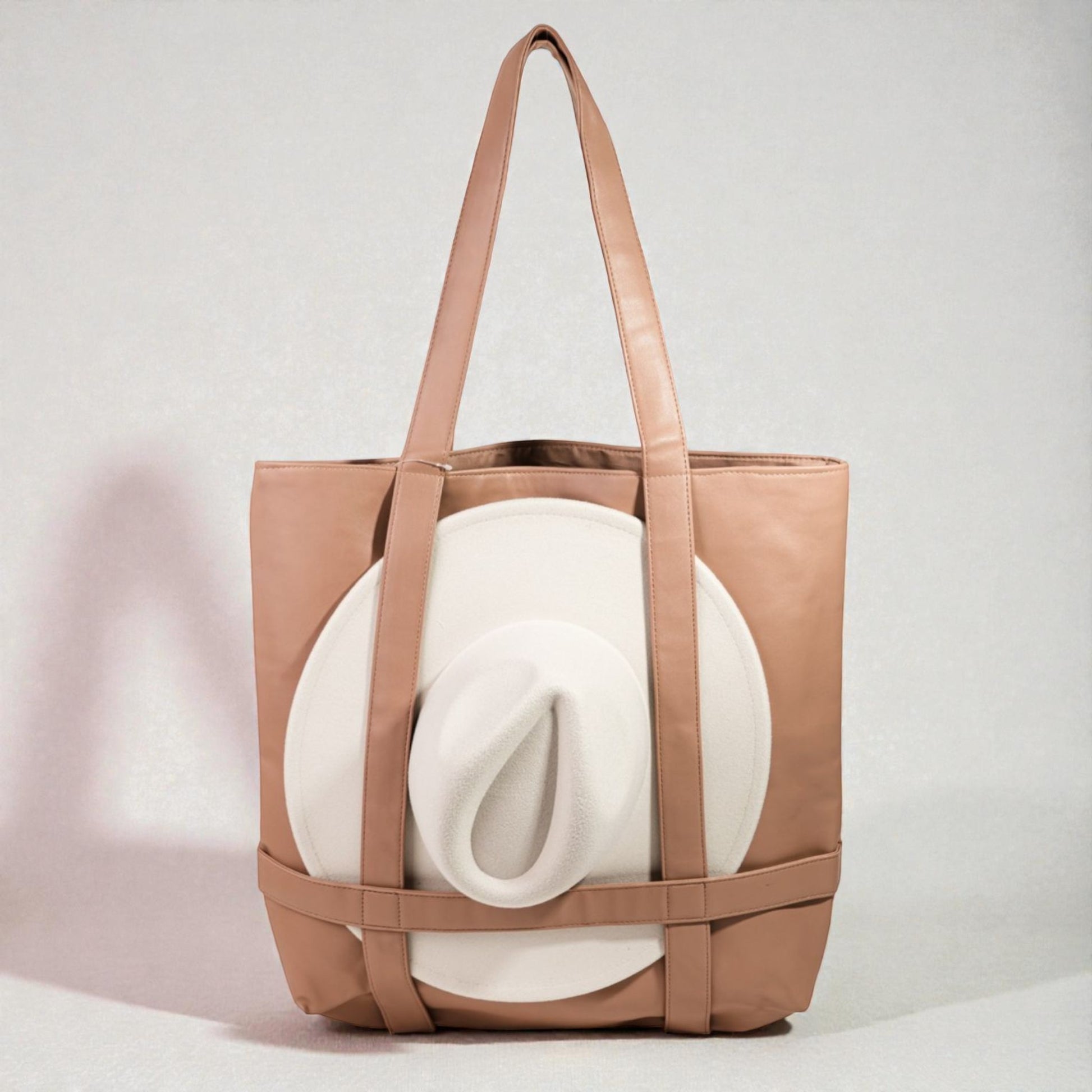Brown tote bag with a white blanket inside on a light gray background