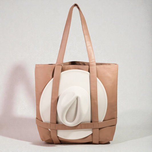 Brown tote bag with a white blanket inside on a light gray background