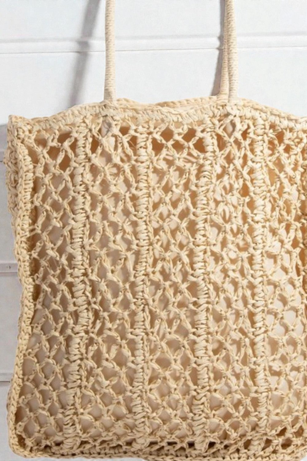 Beige crochet bag with handles on a white background
