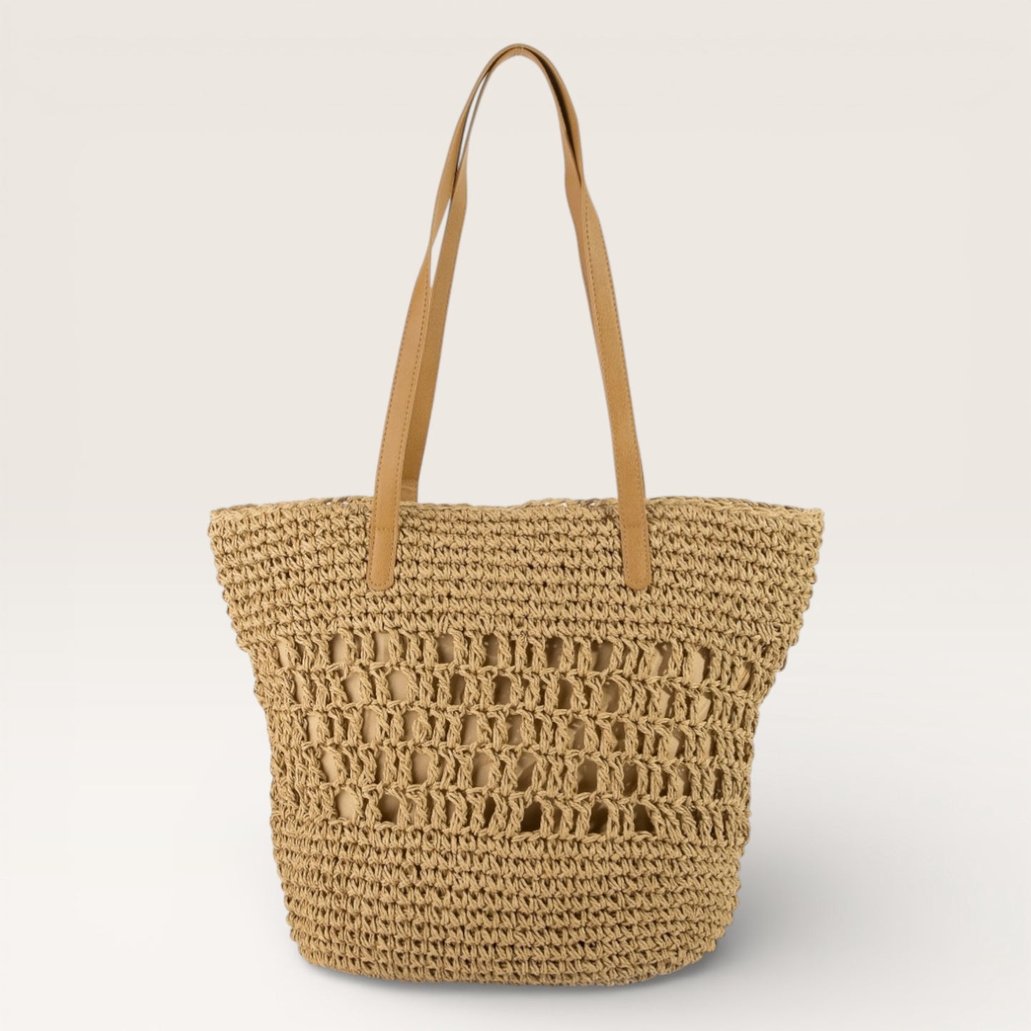 Woven straw tote bag with brown handles on a light beige background