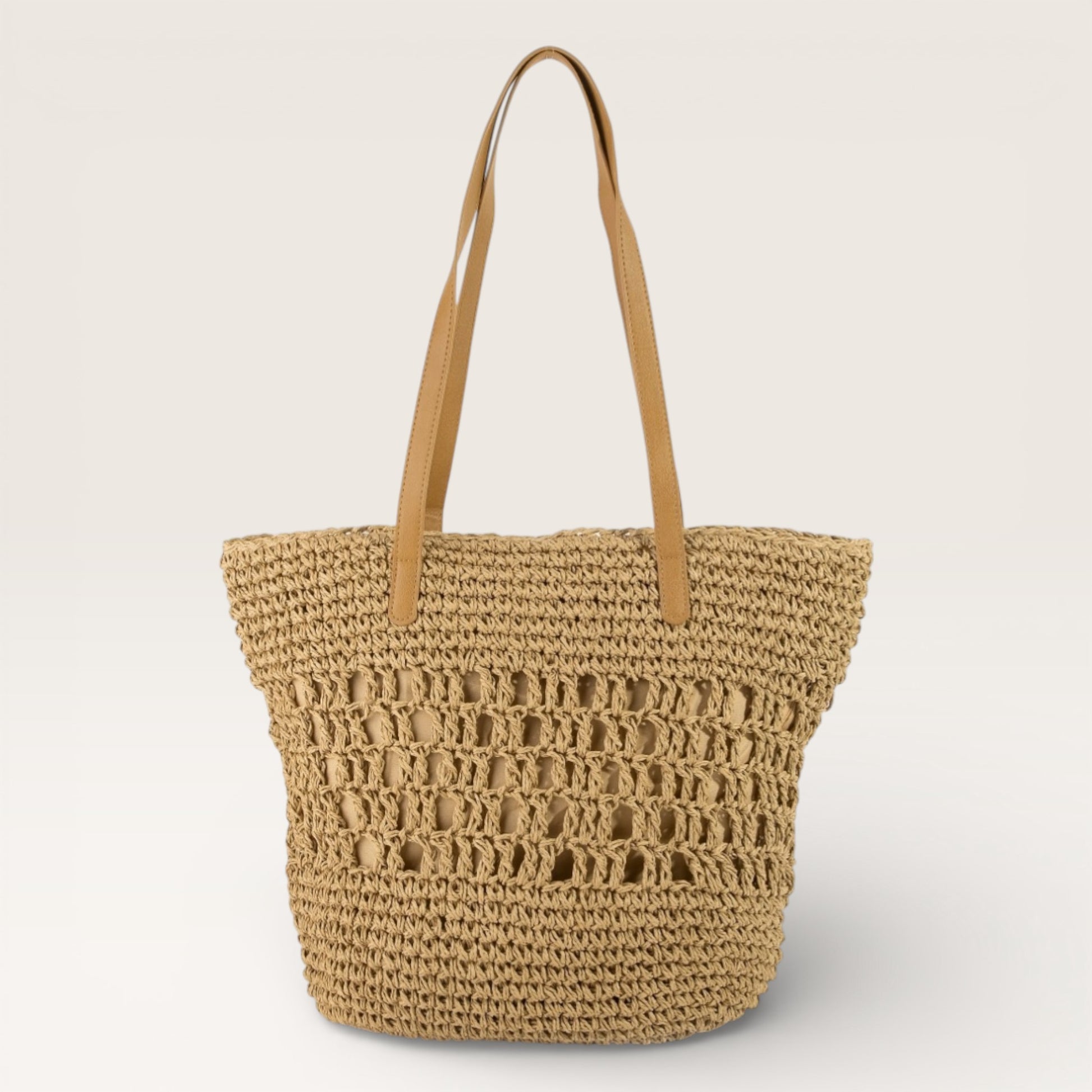 Woven straw tote bag with brown handles on a light beige background