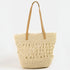 Woven straw tote bag with tan handle on a white background
