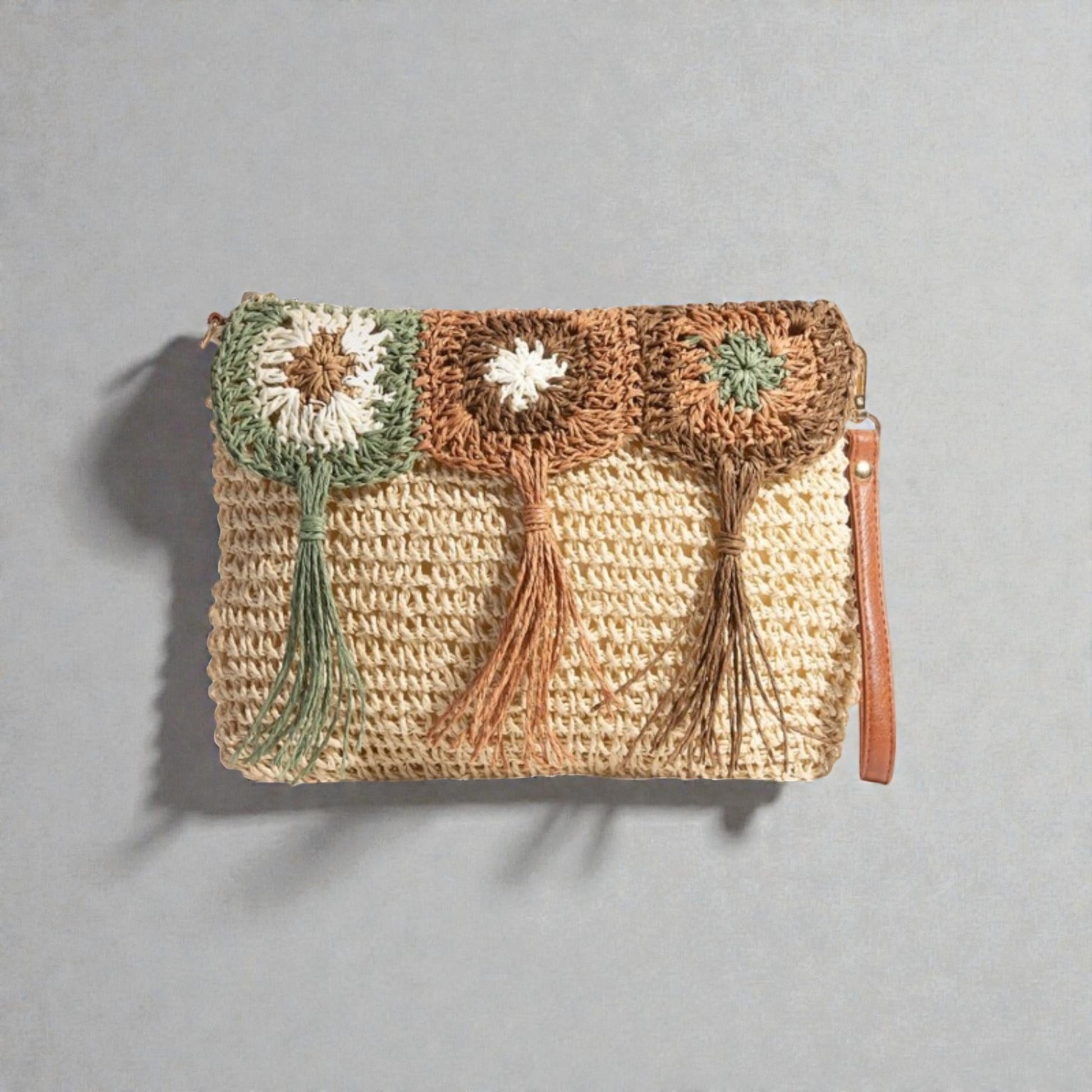Woven clutch bag with floral patterns on a gray background