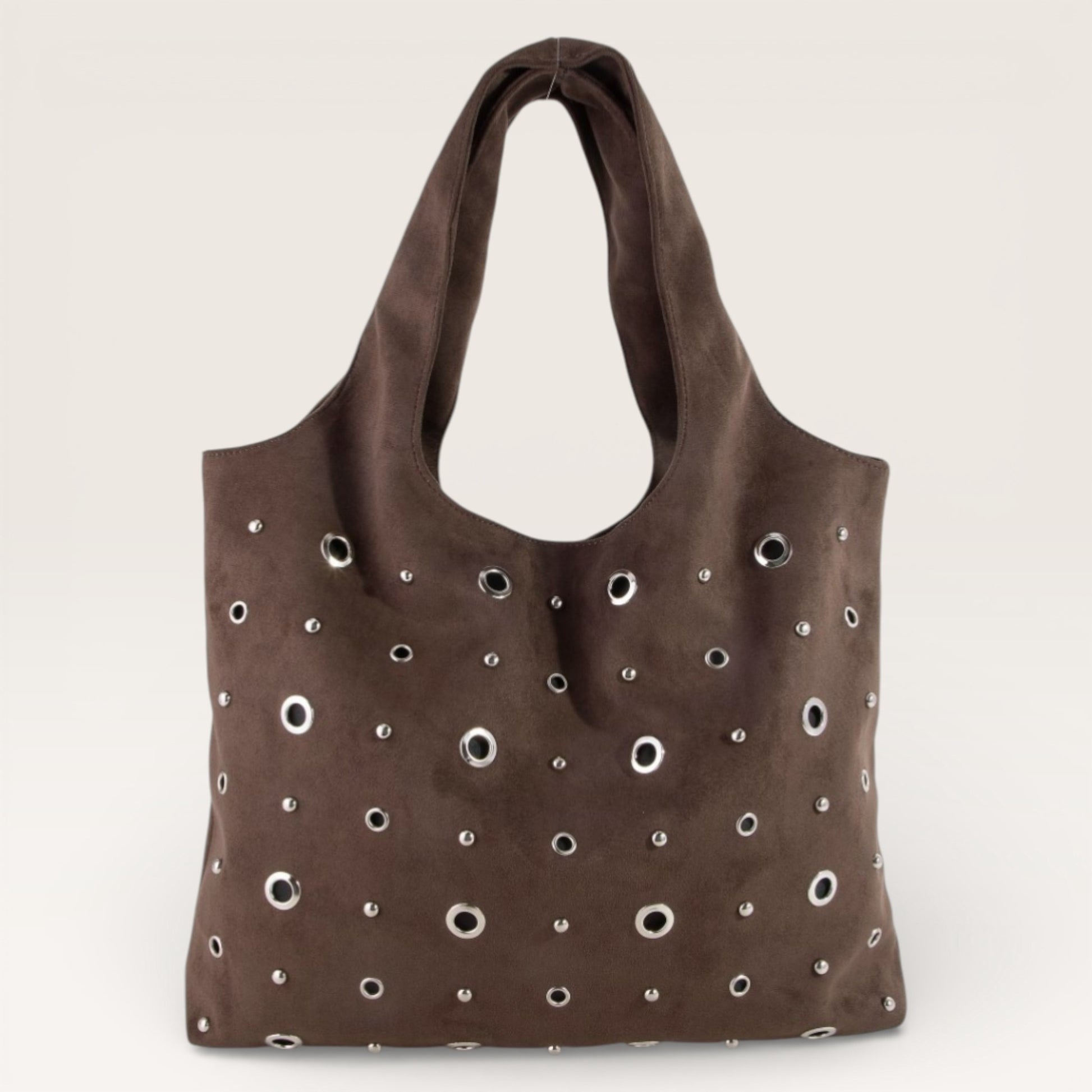 Brown tote bag with eyelet holes on a beige background