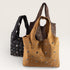 Two handbags, one black and one brown with studs, on a light gray background.