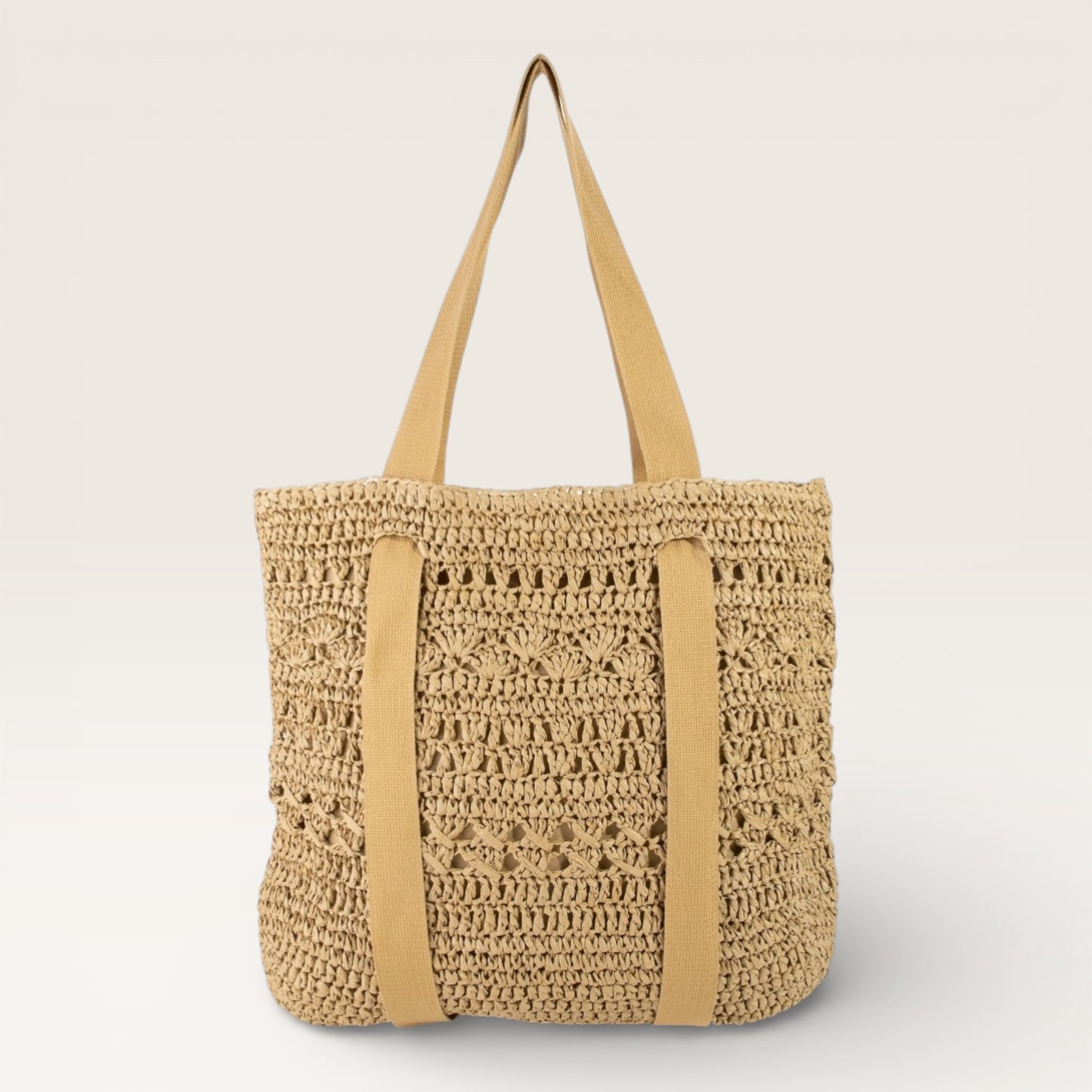 Beige woven tote bag with tan straps on a light gray background