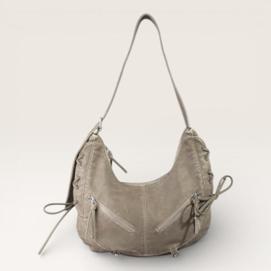 Light brown leather handbag with multiple zippers on a white background