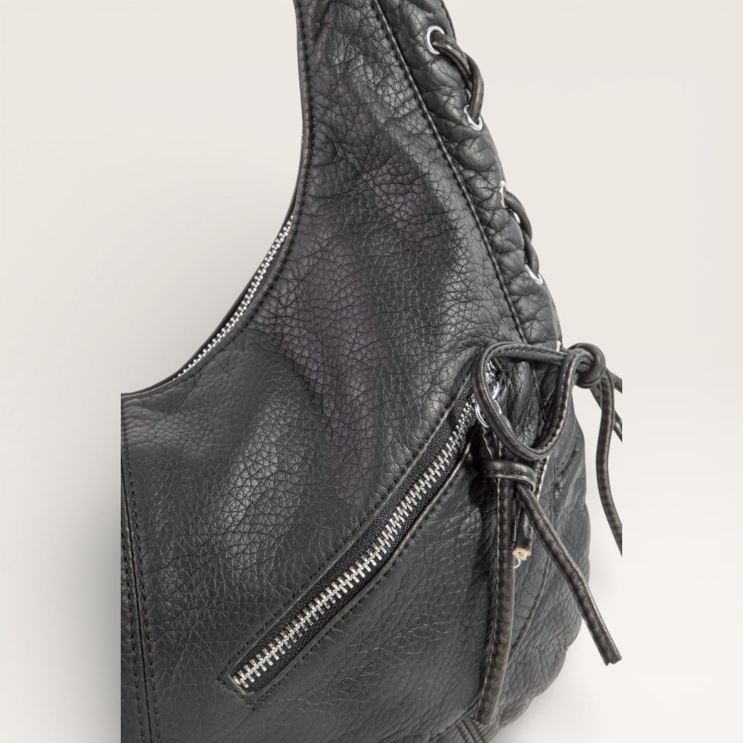 Black leather bag with a zipper on a light gray background