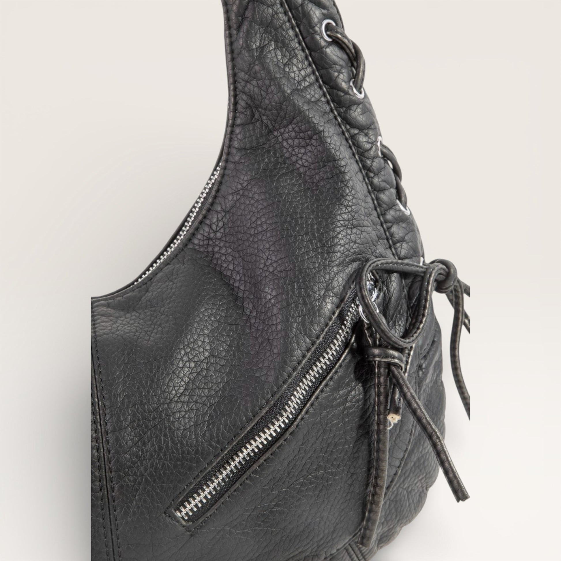 Black leather bag with a zipper on a light gray background