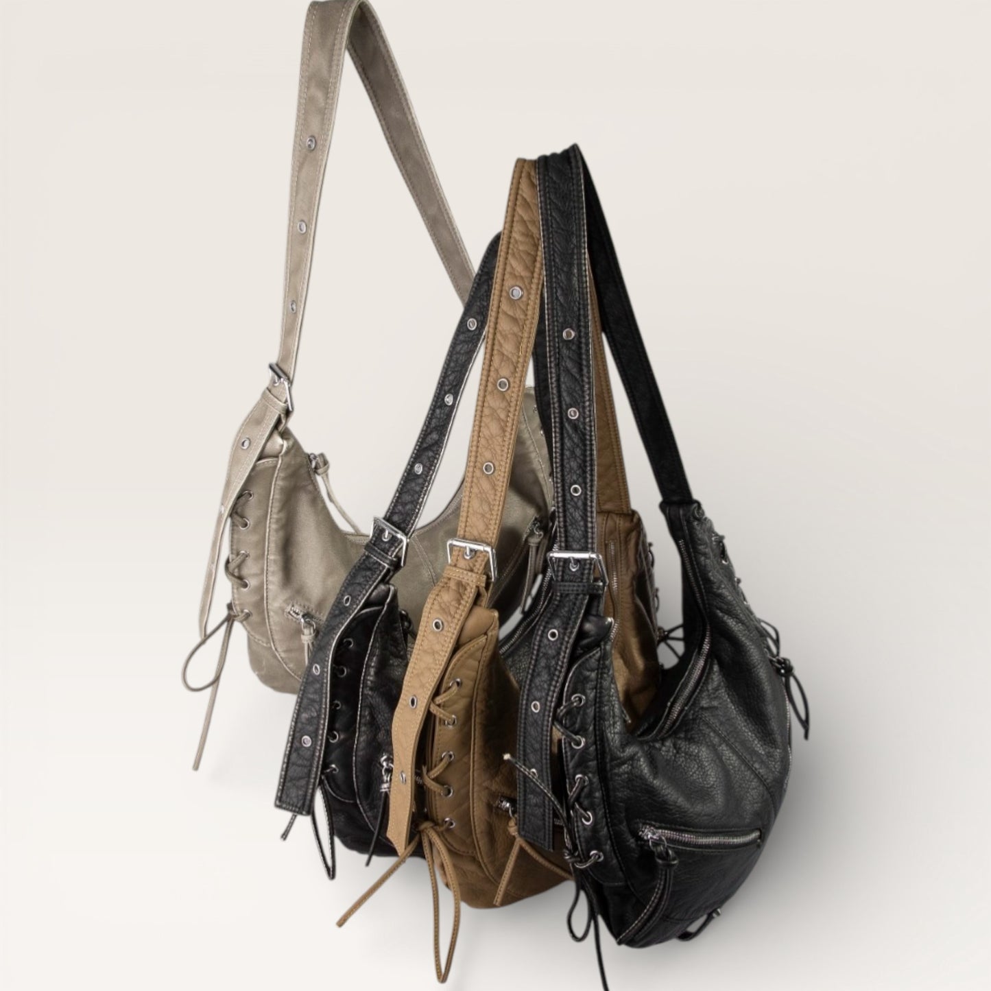 Three leather handbags in different colors on a light background